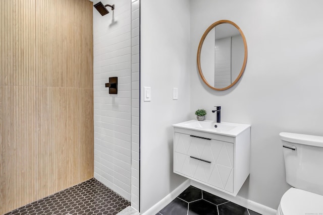 bathroom featuring tile patterned flooring, vanity, toilet, and a shower