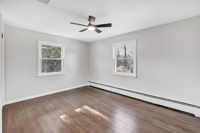 spare room featuring dark hardwood / wood-style flooring, ceiling fan, and a baseboard heating unit