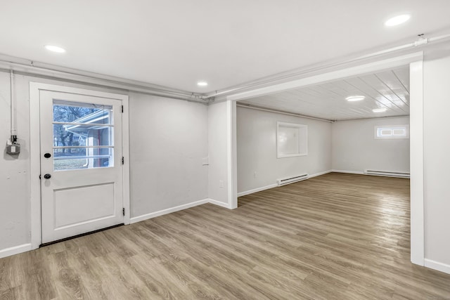 basement featuring a baseboard radiator and light hardwood / wood-style floors