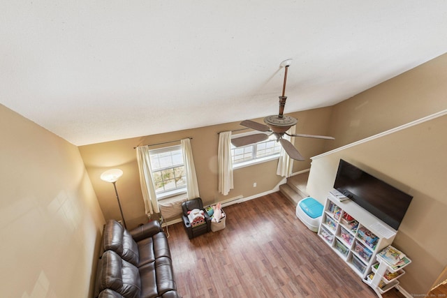 unfurnished living room with ceiling fan, dark hardwood / wood-style flooring, and baseboard heating