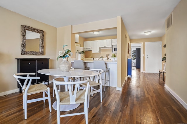 dining area featuring dark hardwood / wood-style flooring and sink