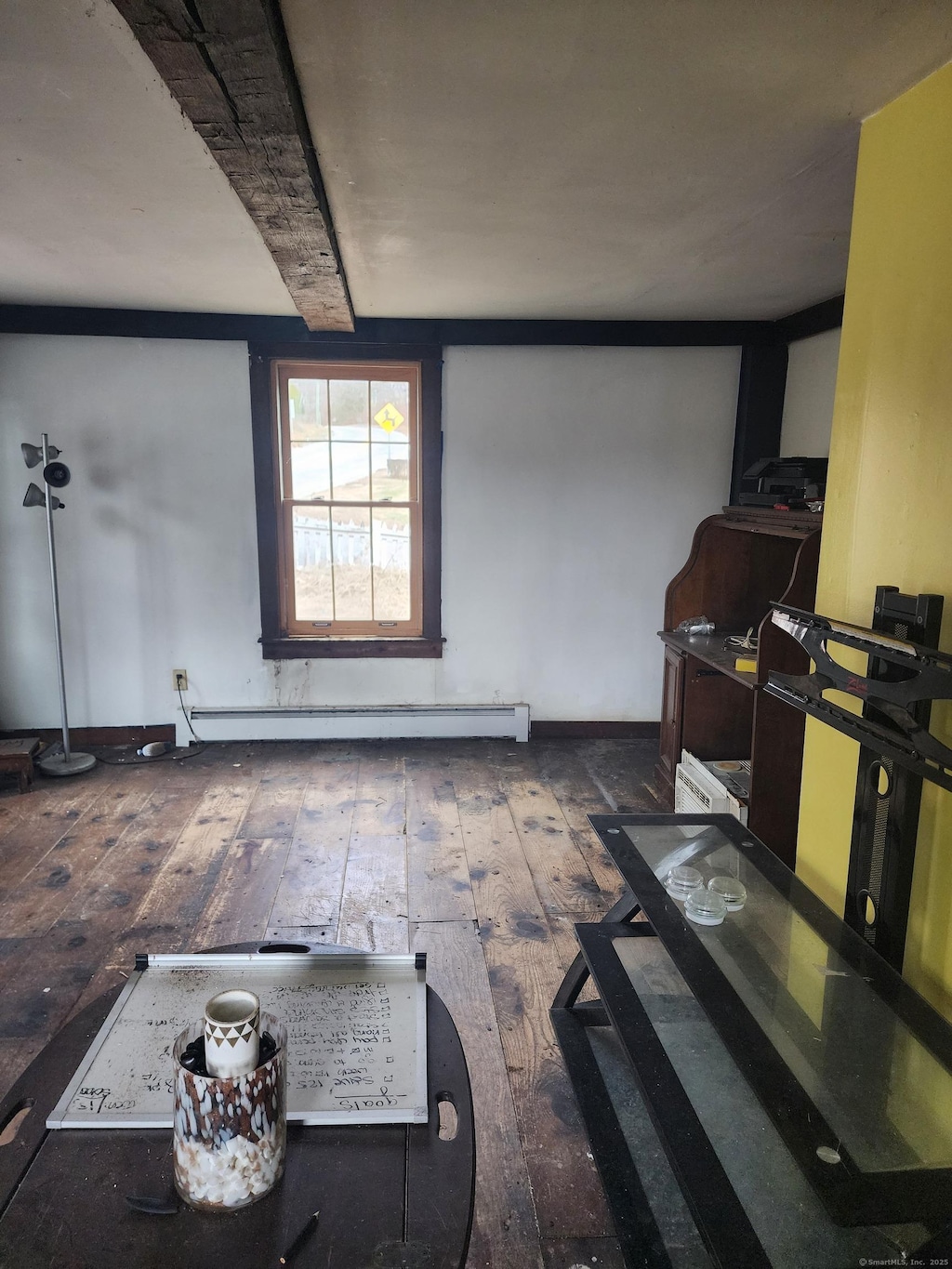 living room featuring beamed ceiling, dark hardwood / wood-style flooring, and a baseboard radiator