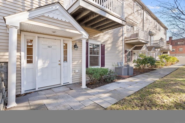 doorway to property with a balcony and central AC unit