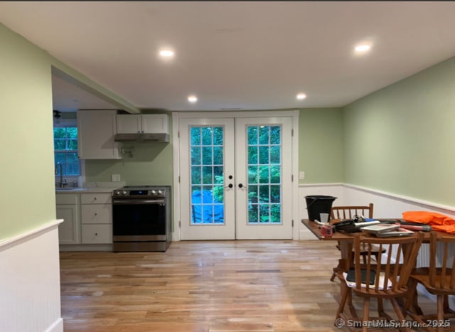 kitchen featuring sink, electric range, light hardwood / wood-style flooring, and french doors