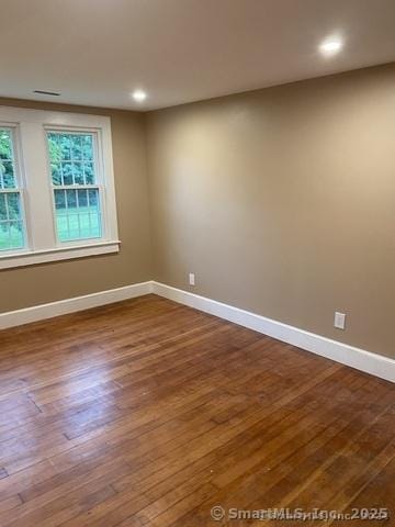 spare room featuring wood-type flooring