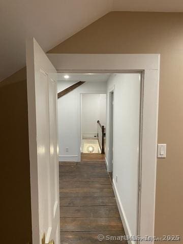 corridor featuring dark hardwood / wood-style flooring and vaulted ceiling