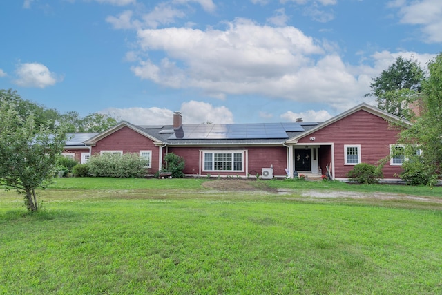 back of house with a yard and solar panels