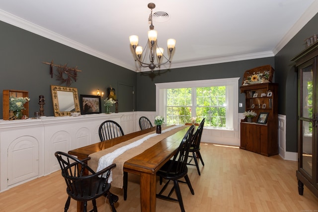 dining area featuring a chandelier, light hardwood / wood-style flooring, and ornamental molding