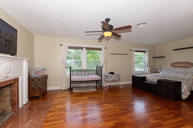 bedroom with multiple windows, ceiling fan, and wood-type flooring