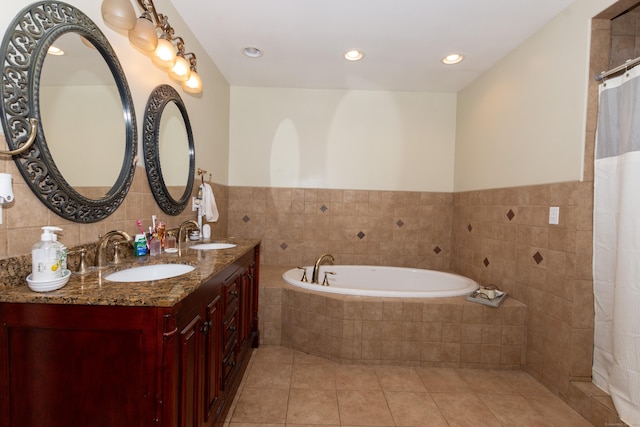 bathroom featuring vanity, tiled bath, tile patterned floors, and tile walls