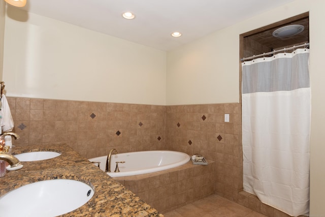 bathroom with tile patterned floors, plus walk in shower, vanity, and tile walls