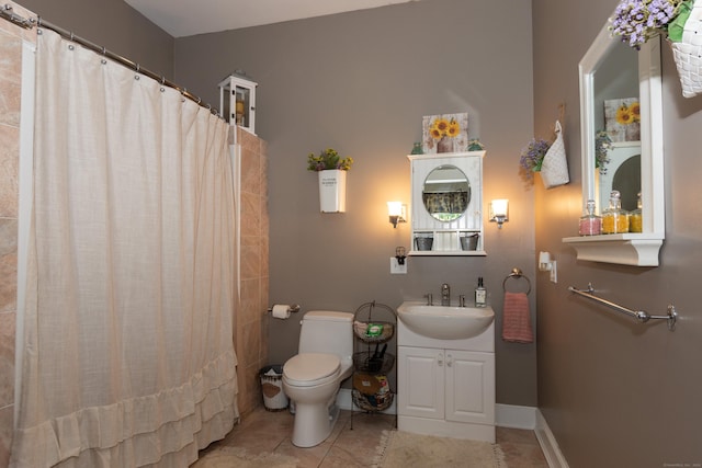 bathroom with tile patterned flooring, vanity, toilet, and walk in shower