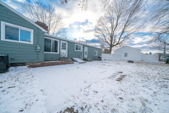 snow covered rear of property featuring central air condition unit