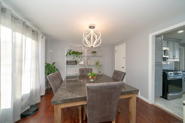 dining area featuring dark hardwood / wood-style floors and an inviting chandelier