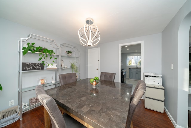 dining space featuring dark hardwood / wood-style flooring, a notable chandelier, and sink