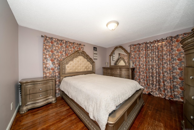 bedroom with a textured ceiling and dark wood-type flooring