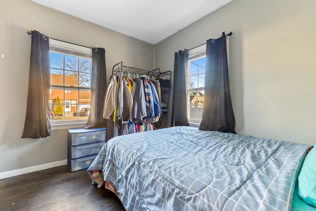 bedroom with multiple windows and dark hardwood / wood-style flooring