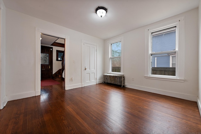 unfurnished room featuring radiator and dark hardwood / wood-style flooring