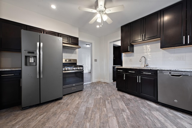 kitchen featuring decorative backsplash, light wood-type flooring, stainless steel appliances, ceiling fan, and sink