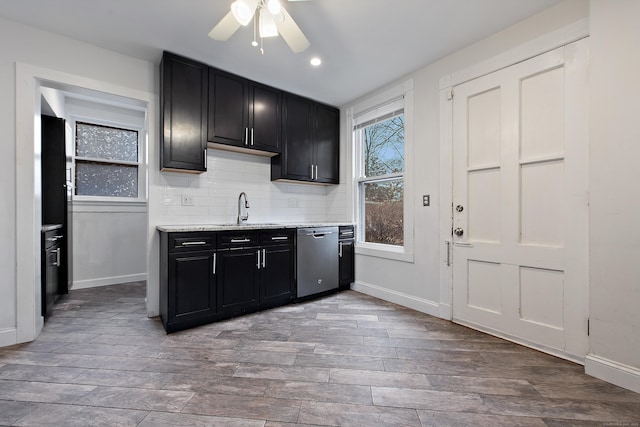 kitchen featuring backsplash, stainless steel dishwasher, ceiling fan, sink, and light hardwood / wood-style floors