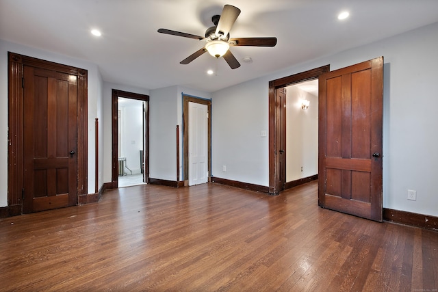 unfurnished bedroom featuring ceiling fan and dark hardwood / wood-style flooring