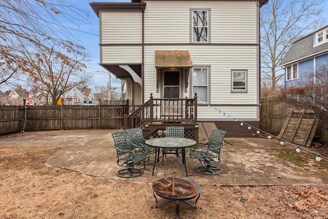 rear view of property featuring a fire pit and a patio area