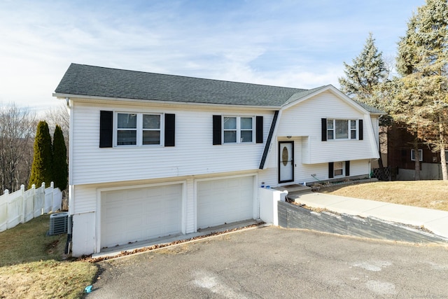 raised ranch with cooling unit and a garage