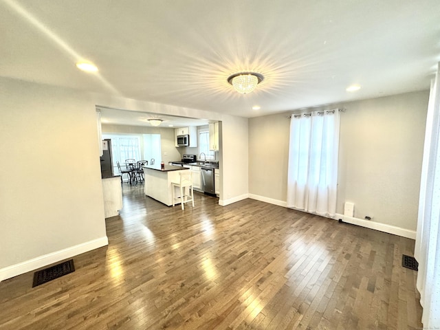 unfurnished living room featuring dark hardwood / wood-style flooring and sink