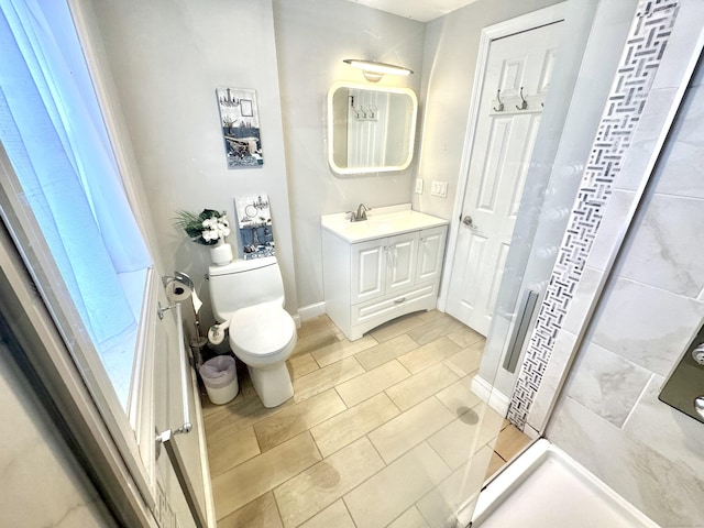 bathroom with walk in shower, vanity, and toilet