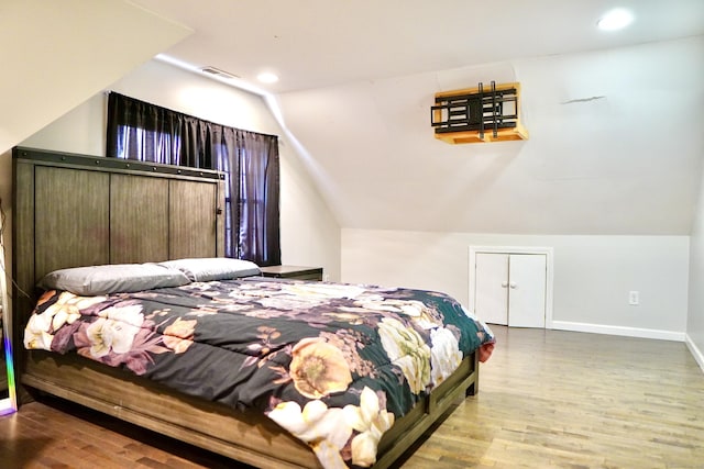 bedroom featuring hardwood / wood-style floors and vaulted ceiling