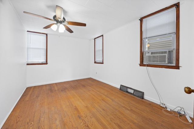 empty room with ceiling fan, cooling unit, and hardwood / wood-style flooring