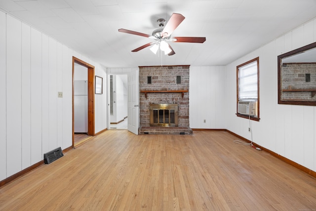 unfurnished living room with ceiling fan, a fireplace, cooling unit, and light hardwood / wood-style flooring