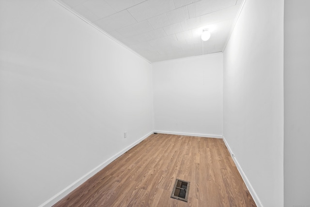 spare room with hardwood / wood-style floors and ornamental molding