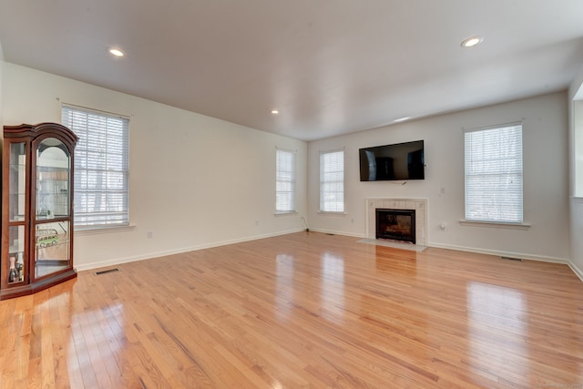 unfurnished living room featuring light hardwood / wood-style floors and a fireplace