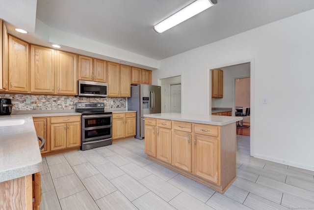 kitchen featuring light brown cabinets, sink, decorative backsplash, a kitchen island, and stainless steel appliances