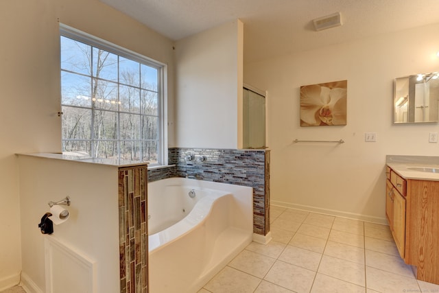 bathroom with tile patterned floors, a bathing tub, vanity, and a textured ceiling