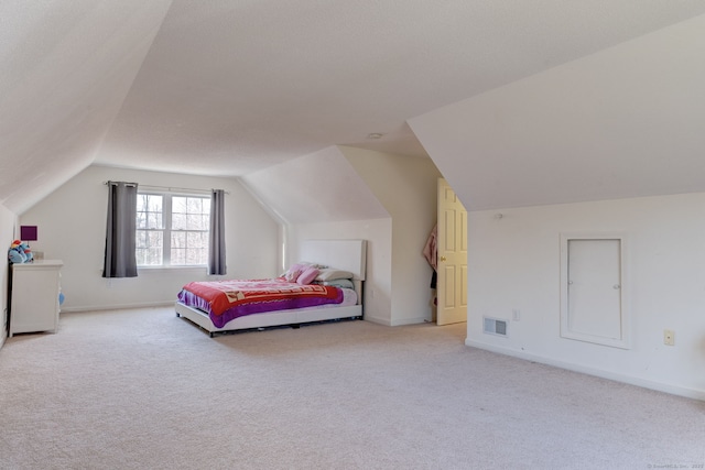 bedroom featuring light carpet and vaulted ceiling