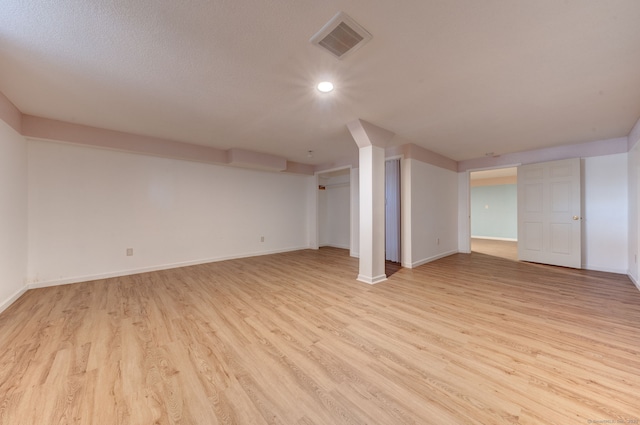 basement with light hardwood / wood-style flooring