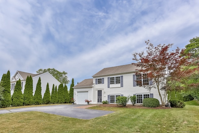 colonial home featuring a front lawn and a garage