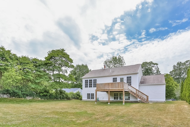 rear view of house featuring a wooden deck and a yard