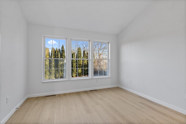 empty room with plenty of natural light and light hardwood / wood-style flooring