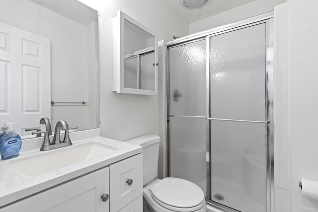 bathroom featuring toilet, vanity, and walk in shower