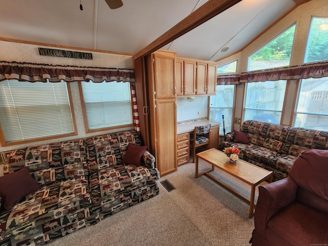 living room with ceiling fan, light carpet, and vaulted ceiling