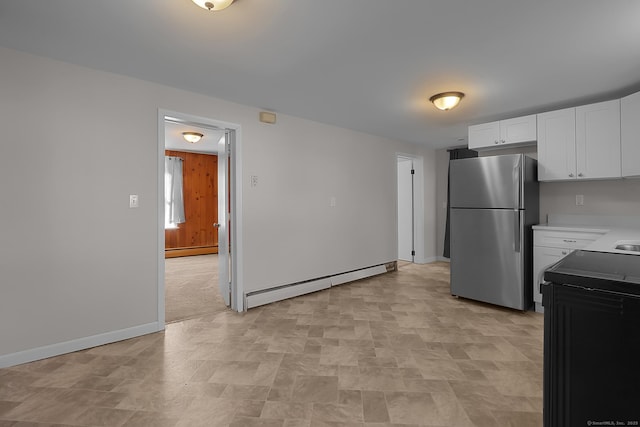 kitchen with stainless steel fridge, electric range oven, white cabinetry, and baseboard heating