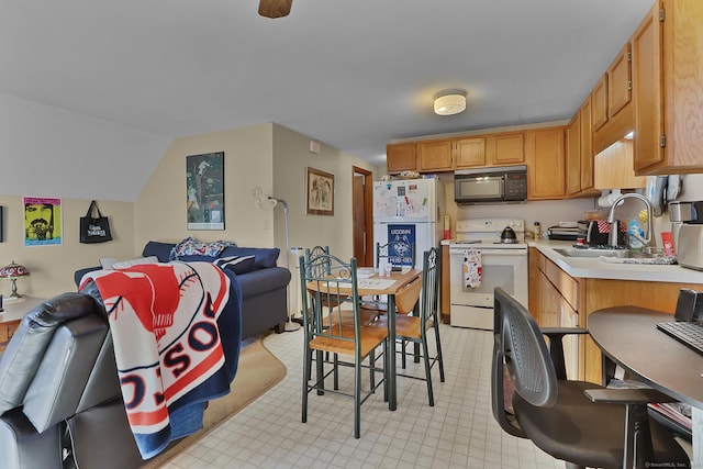 kitchen with lofted ceiling, sink, and white appliances