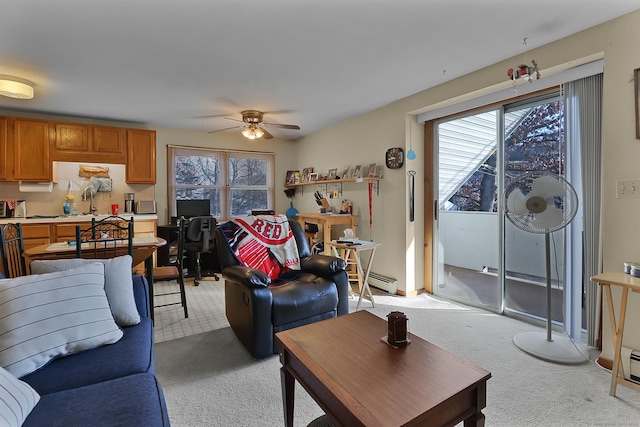 living room featuring light colored carpet, ceiling fan, a baseboard heating unit, and sink