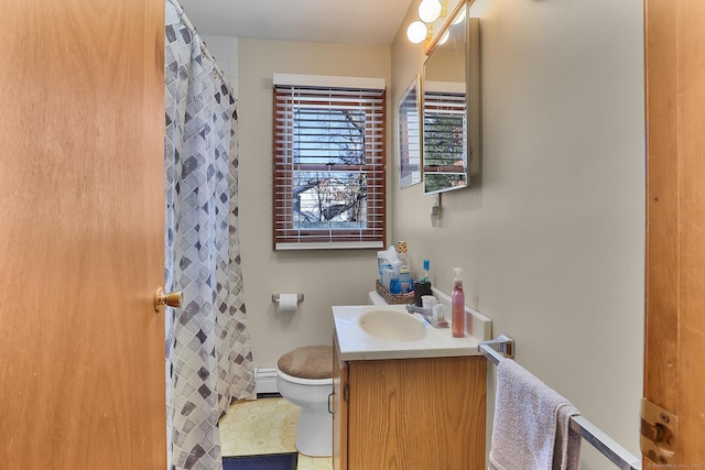 bathroom featuring vanity, toilet, and baseboard heating