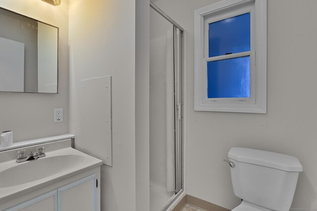 bathroom with vanity, toilet, and an enclosed shower