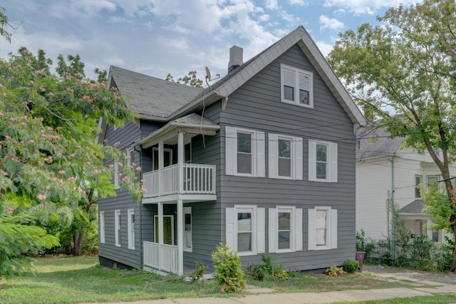 back of house featuring a yard and a balcony