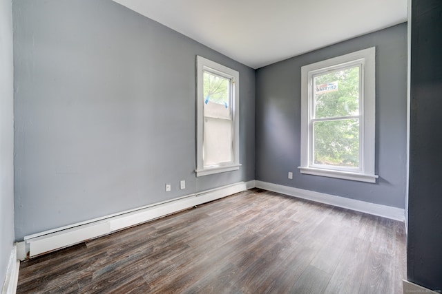 spare room with wood-type flooring and baseboard heating